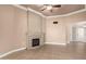 Neutral living room with a decorative fireplace, ceiling fan, and tile flooring at 13628 N 109Th Ave, Sun City, AZ 85351