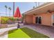 Relaxing patio with an outdoor seating area, lush greenery, and a vibrant red umbrella at 13628 N 109Th Ave, Sun City, AZ 85351