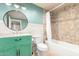 Bathroom with tiled shower over tub, wainscotting, granite vanity, and round mirror at 14027 N 32Nd St, Phoenix, AZ 85032