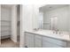 Bathroom featuring double sink vanity with modern fixtures, white cabinets and quartz countertops at 15378 W Cottontail Ln, Surprise, AZ 85387