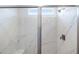 Glass shower with a white marble-look surround, a shower head, and a built-in bench at 15378 W Cottontail Ln, Surprise, AZ 85387