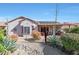 Desert landscaped backyard with solar panels, a covered patio, native plants, and rock accents at 16017 W Wildflower Dr, Surprise, AZ 85374