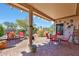 Charming covered patio with red brick pavers, outdoor furniture, and views of the desert landscaping at 16017 W Wildflower Dr, Surprise, AZ 85374