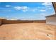 Large undeveloped backyard featuring a large dirt area, and a block wall in the distance at 16749 W Whispering Wind Dr, Surprise, AZ 85387
