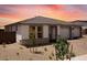 A charming single-story home boasts a well-manicured lawn and a three-car garage, offering both curb appeal and practicality at 16749 W Whispering Wind Dr, Surprise, AZ 85387