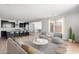 Open-concept living room showcasing seamless flow to the kitchen, complete with modern furnishings and neutral tones at 16749 W Whispering Wind Dr, Surprise, AZ 85387