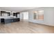 Open-concept living room showcasing hardwood floors and a view into the modern kitchen at 16749 W Whispering Wind Dr, Surprise, AZ 85387