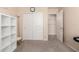 Bedroom featuring carpet, storage shelves and closet with sliding doors, providing space-saving storage at 17532 W Caribbean Ln, Surprise, AZ 85388