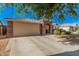 Single-story home with tile roof, a two car garage and low maintenance desert landscaping at 17532 W Caribbean Ln, Surprise, AZ 85388