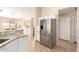 Kitchen with stainless steel refrigerator, granite counters, white cabinets, and tile floors at 17532 W Caribbean Ln, Surprise, AZ 85388