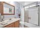 Bright bathroom with a shower and tub combination, oak vanity, and mirrored cabinet at 18254 N 136Th Ave, Sun City West, AZ 85375