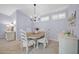 Charming dining room with a chandelier, lovely table setting, and bright light from the window shutters at 18254 N 136Th Ave, Sun City West, AZ 85375