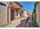 Cozy front porch with seating area, security door, potted plants, and desert landscaping at 18254 N 136Th Ave, Sun City West, AZ 85375