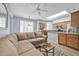 Open concept living room and kitchen with neutral tones, skylight, and ample seating on a large sectional at 18254 N 136Th Ave, Sun City West, AZ 85375