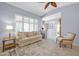 Inviting living room with plantation shutters, ceiling fan, neutral color palette and comfortable sofa at 18254 N 136Th Ave, Sun City West, AZ 85375