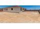 Exterior view of a home showcasing the expansive backyard with a covered patio at 18347 W Monte Lindo Ln, Surprise, AZ 85387