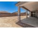 View of a home's backyard featuring a covered patio with concrete flooring and a block wall around the property at 18347 W Monte Lindo Ln, Surprise, AZ 85387