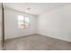 Bright, empty bedroom showcasing tile floors, a window, and plenty of natural light at 18347 W Monte Lindo Ln, Surprise, AZ 85387