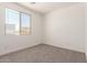 Carpeted bedroom with a bright window to offer a view of the neighborhood at 18347 W Monte Lindo Ln, Surprise, AZ 85387
