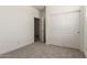 Spacious carpeted bedroom featuring closet storage, neutral tones and a view into another room at 18347 W Monte Lindo Ln, Surprise, AZ 85387