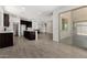 Bright, open-concept living area showcasing tile floors and kitchen access at 18347 W Monte Lindo Ln, Surprise, AZ 85387