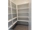 Spacious walk-in pantry with built-in white shelving for optimal storage at 18347 W Monte Lindo Ln, Surprise, AZ 85387