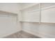 Bright walk-in closet featuring custom shelving and ample storage space for organization at 18347 W Monte Lindo Ln, Surprise, AZ 85387