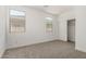 A bright bedroom with two windows and a closet with sliding doors at 18363 W Monte Lindo Ln, Surprise, AZ 85387