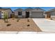 Inviting single-story house with a two-car garage, desert landscaping, and a well-maintained lawn at 18363 W Monte Lindo Ln, Surprise, AZ 85387