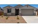 Charming single-story home featuring a neutral color scheme, desert landscaping, and an attached two-car garage at 18363 W Monte Lindo Ln, Surprise, AZ 85387