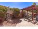 Serene backyard featuring a stone waterfall feature, lush landscaping, and a charming pergola-covered dining area at 2101 S Meridian Rd # 60, Apache Junction, AZ 85120