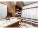 This is a cozy bathroom with dark wooden cabinets and drawers and white shower curtains at 2101 S Meridian Rd # 60, Apache Junction, AZ 85120