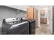 Laundry room features gray washer and dryer with wooden storage at 2242 W Calle Marita --, Phoenix, AZ 85085