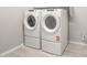 Modern laundry room with front load washer and dryer on pedestals and built in shelving at 26650 W Siesta Ln, Buckeye, AZ 85396