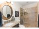 Bathroom featuring granite vanity, round mirror, and glass-enclosed tile shower at 36600 N Cave Creek Rd # 9B, Cave Creek, AZ 85331