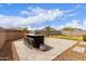 A backyard oasis featuring a custom outdoor kitchen with a bar, perfect for entertaining, surrounded by a well-manicured lawn at 36728 N Alderney Ct, San Tan Valley, AZ 85143