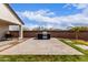 Outdoor kitchen and backyard showcasing modern patio design with a built-in grill area and lush green grass at 36728 N Alderney Ct, San Tan Valley, AZ 85143