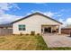 Backyard features a covered patio, lush green lawn, and a stylish outdoor kitchen area, perfect for outdoor living at 36728 N Alderney Ct, San Tan Valley, AZ 85143