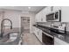 This kitchen features white cabinets, gray counters, and stainless steel appliances at 36728 N Alderney Ct, San Tan Valley, AZ 85143