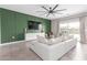 Modern living room showcases a large, comfortable couch, stylish green accent wall, and plenty of natural light at 36728 N Alderney Ct, San Tan Valley, AZ 85143