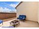 Cozy outdoor patio area featuring comfortable blue seating, a modern fire pit, and a textured wall at 36728 N Alderney Ct, San Tan Valley, AZ 85143