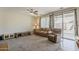 Inviting living room with plush carpet, ceiling fan, neutral tones, and sliding glass doors to the outside at 3816 E Phelps St, Gilbert, AZ 85295