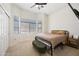 Bedroom with a bed, bay window, ceiling fan, neutral carpet and adjacent sliding door closet at 417 S 89Th Way, Mesa, AZ 85208