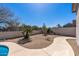 Low-maintenance desert landscape backyard with a meandering sidewalk and block wall perimeter at 7329 W Tether Trl, Peoria, AZ 85383