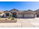 Charming single-story home featuring a three-car garage, desert landscaping, and a tile roof at 7329 W Tether Trl, Peoria, AZ 85383