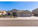 Lovely single-story home featuring a three-car garage and desert landscaping with a tile roof at 7329 W Tether Trl, Peoria, AZ 85383