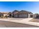 Charming home featuring a three-car garage, desert landscaping, and a well-maintained front yard at 7329 W Tether Trl, Peoria, AZ 85383