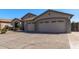 Spacious three-car garage with decorative windows and a tile roof on a single-story home at 7329 W Tether Trl, Peoria, AZ 85383