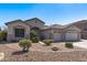 Well-maintained single-story home with desert landscaping, rock accents, and a tile roof at 7329 W Tether Trl, Peoria, AZ 85383