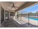 Covered patio space with a ceiling fan, providing a cool retreat with views of the fenced pool area at 7329 W Tether Trl, Peoria, AZ 85383